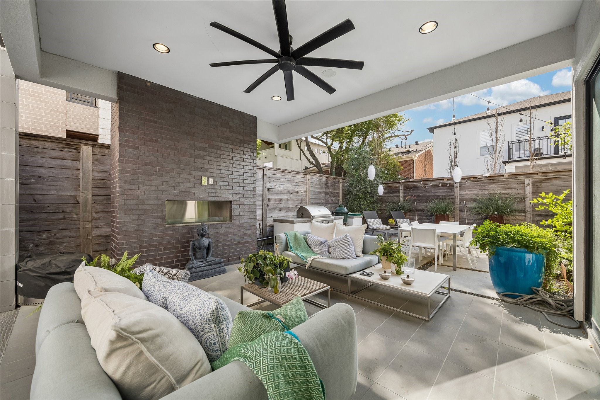 2014 Park Street Houston, TX 77019 - Photo 12 of 40 This inviting outdoor living area features a cozy fireplace and offers views of the stylish outdoor kitchen and lush planting area, perfect for entertaining and relaxation.