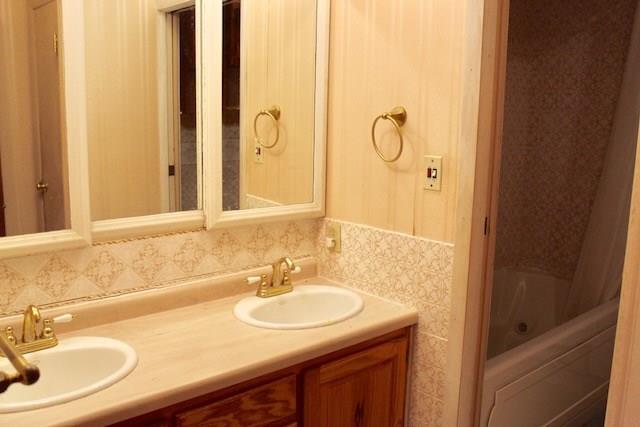 471 County Road Slickville, PA 15684 - Photo 12 of 25 Main floor bath with dual sinks and separate tub/shower and toilet area. Can be accessed from main floor hall or master bedroom.