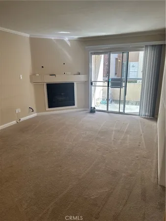 a view of an empty room with a fireplace and a window