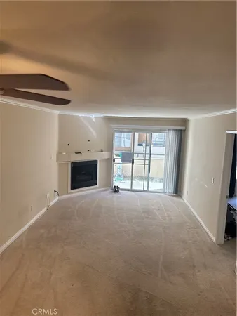 a view of an empty room with a fireplace and a window