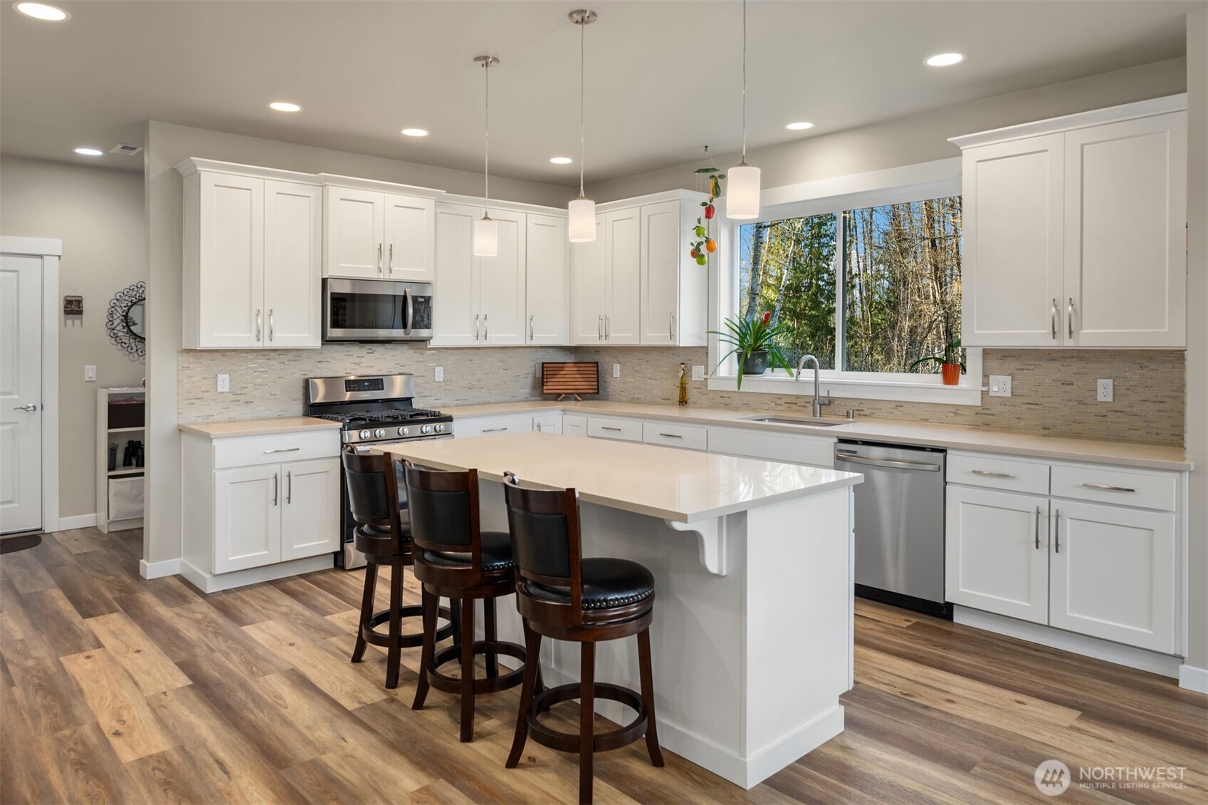 20927 60th Street Southeast Snohomish, WA 98290 - Photo 11 of 40 a kitchen with stainless steel appliances granite countertop a white cabinets and wooden floor
