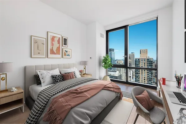 a bedroom with a bed table flowerpot and window