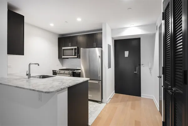 a kitchen with stainless steel appliances granite countertop a refrigerator and a sink