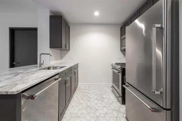 a kitchen with stainless steel appliances granite countertop a sink stove and refrigerator