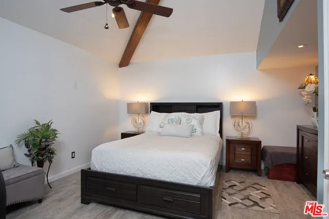 a bedroom with a bed a couch and potted plant