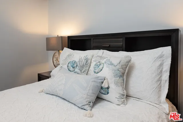 a large bed sitting in a bedroom next to a window