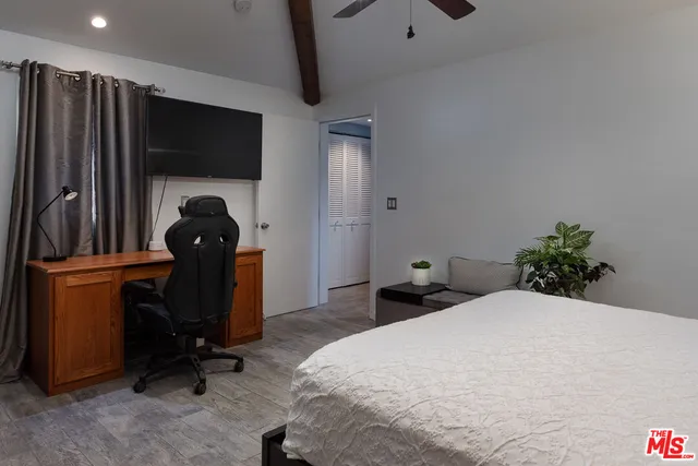 a bedroom with a bed and a flat screen tv