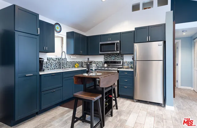 a kitchen with a refrigerator a stove a microwave a sink and cabinets