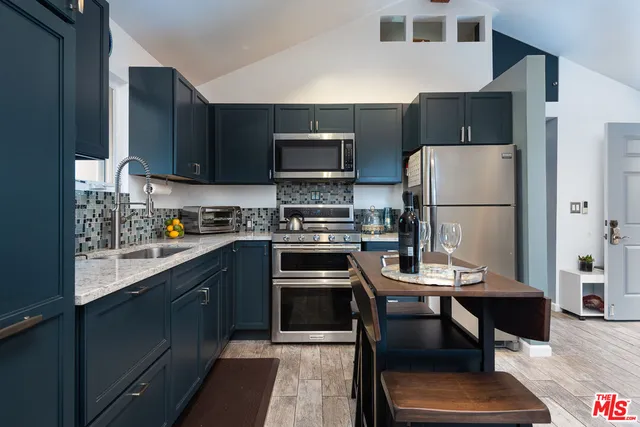 a kitchen with a refrigerator a stove a microwave and a dining table