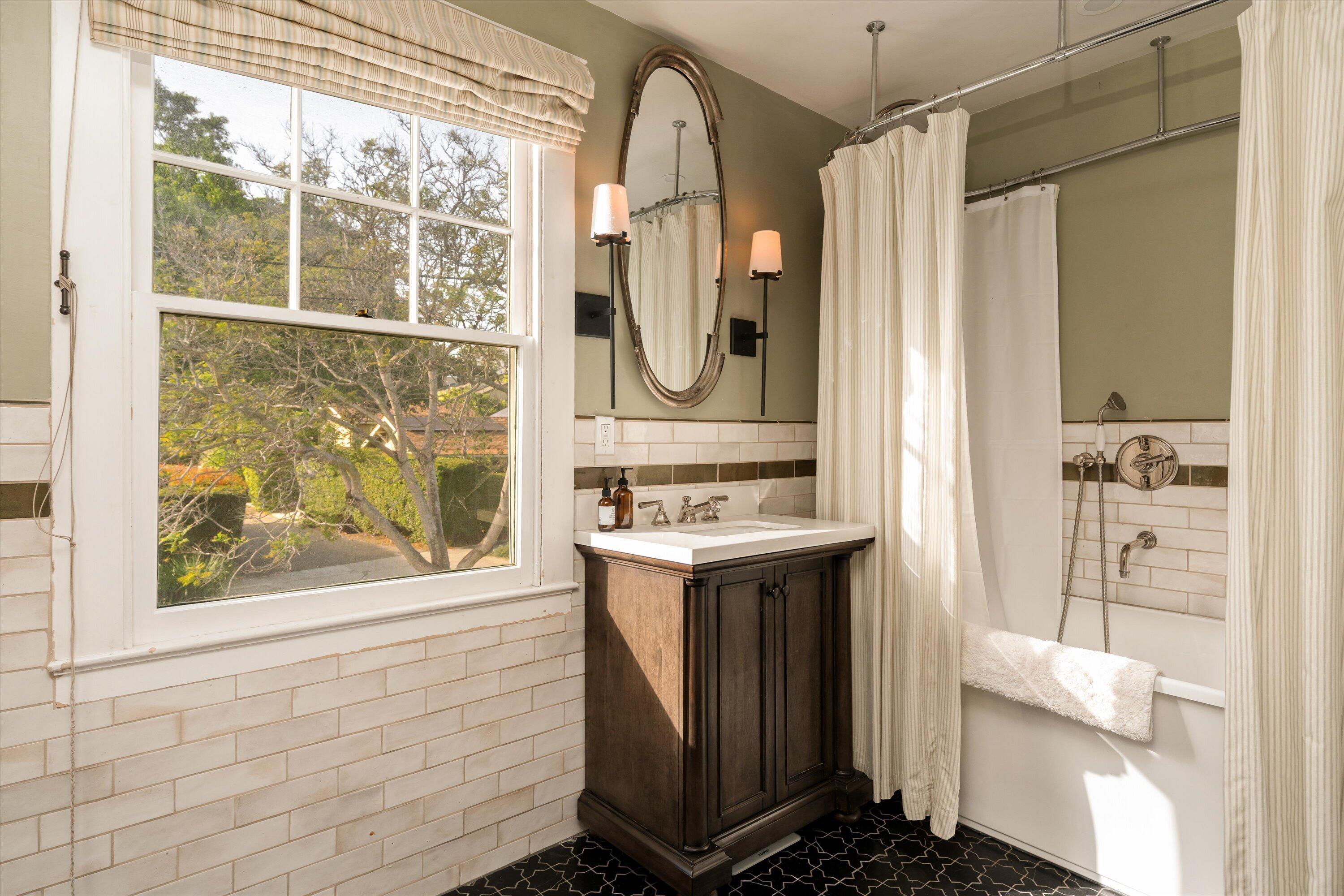 22 East Islay Street Santa Barbara, CA 93101 - Photo 16 of 26 a bathroom with a sink a mirror a window and a shower