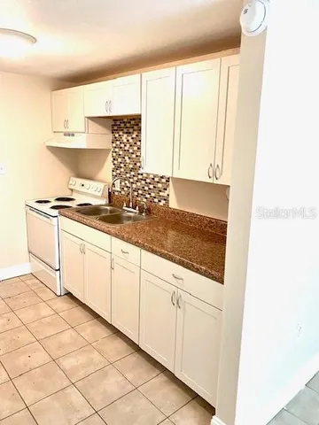 a kitchen with granite countertop white cabinets and white appliances