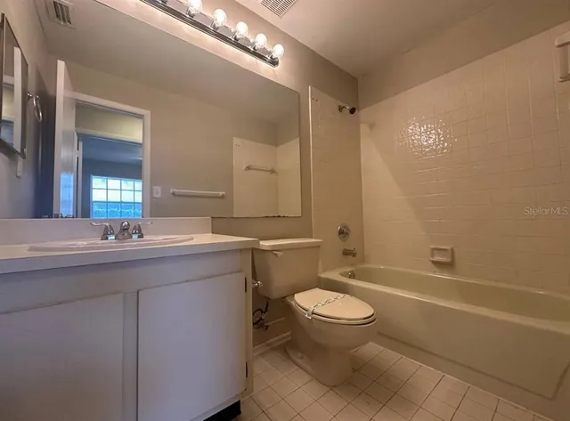 a bathroom with a granite countertop toilet sink and mirror