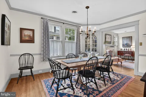 a living room with furniture a large window and wooden floor