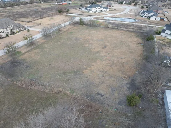 a view of a dry yard with wooden fence