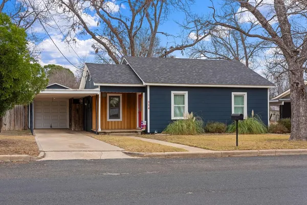 a front view of a house with a garden and yard