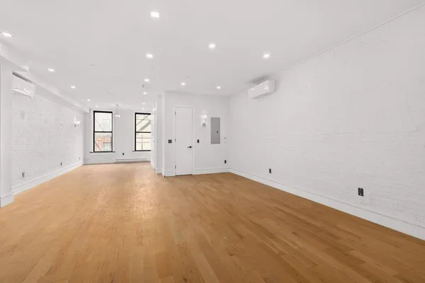 a living room with furniture a potted plant and kitchen view