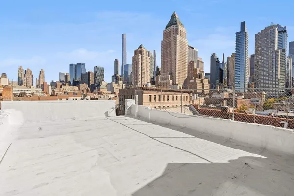 a view of an empty room with wooden floor and stairs