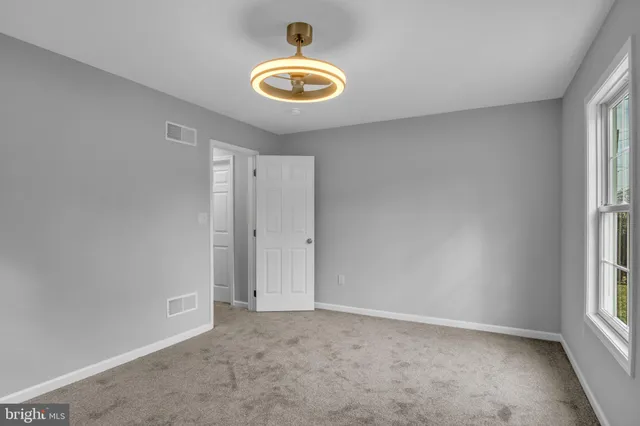 an empty room that has a window and a hallway