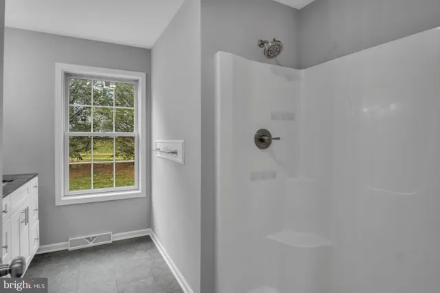 a bathroom with a granite countertop sink a mirror and a window