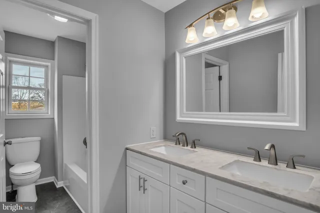 a bathroom with a granite countertop sink mirror and double