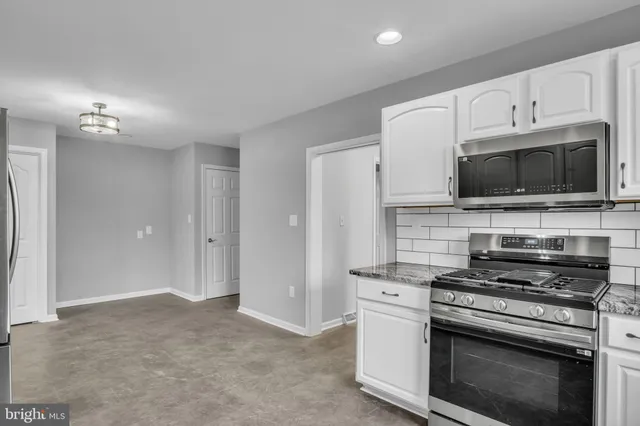 a kitchen with stainless steel appliances granite countertop a refrigerator and a stove top oven