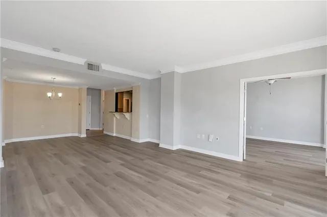 a view of a room with wooden floor and a ceiling fan