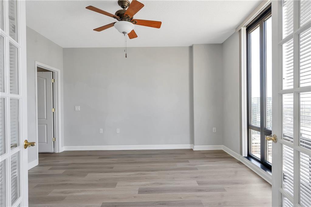3475 Oak Valley Road Northeast, Unit 1930 Atlanta, GA 30326 - Photo 12 of 29 a view of a room with wooden floor and a ceiling fan