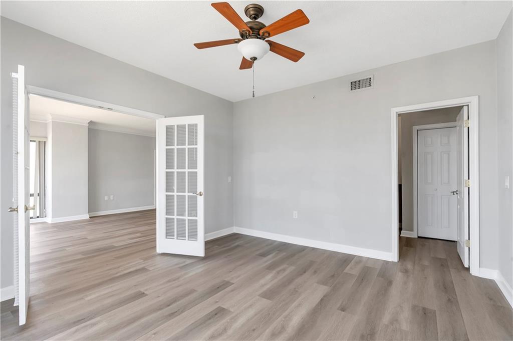 3475 Oak Valley Road Northeast, Unit 1930 Atlanta, GA 30326 - Photo 14 of 29 an empty room with wooden floor ceiling fan and windows