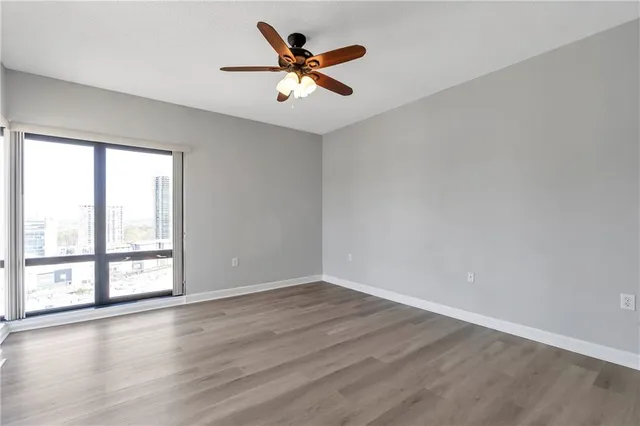 a view of a big room with wooden floor closet and windows