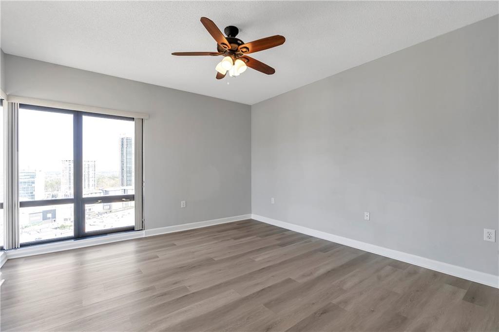 3475 Oak Valley Road Northeast, Unit 1930 Atlanta, GA 30326 - Photo 16 of 29 an empty room with wooden floor and windows