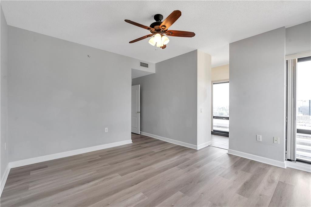 3475 Oak Valley Road Northeast, Unit 1930 Atlanta, GA 30326 - Photo 18 of 29 an empty room with wooden floor and ceiling fan