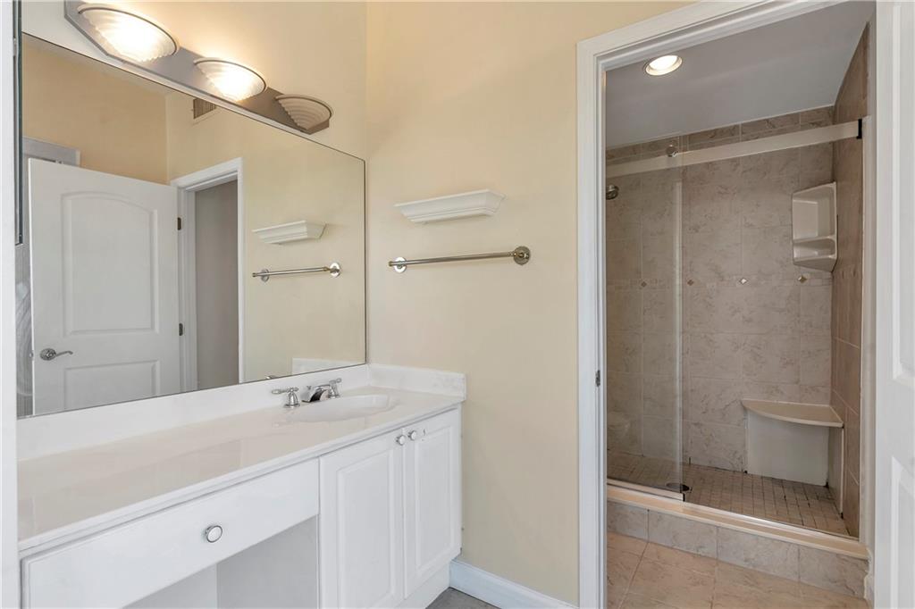 3475 Oak Valley Road Northeast, Unit 1930 Atlanta, GA 30326 - Photo 19 of 29 a spacious bathroom with a shower sink and mirror