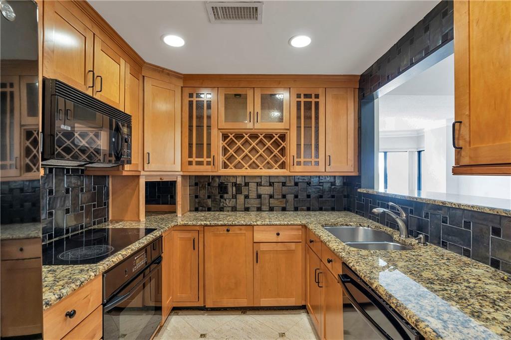 3475 Oak Valley Road Northeast, Unit 1930 Atlanta, GA 30326 - Photo 26 of 29 a kitchen with granite countertop a sink and a stove top oven