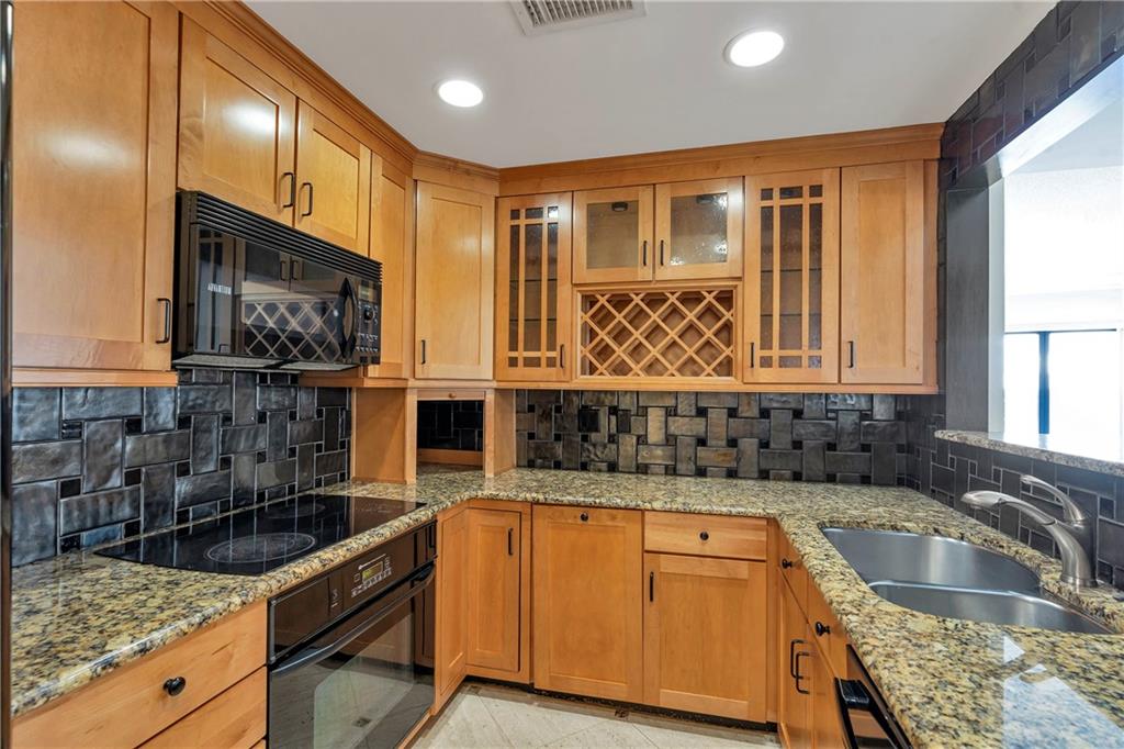 3475 Oak Valley Road Northeast, Unit 1930 Atlanta, GA 30326 - Photo 27 of 29 a kitchen with stainless steel appliances granite countertop a sink stove and cabinets