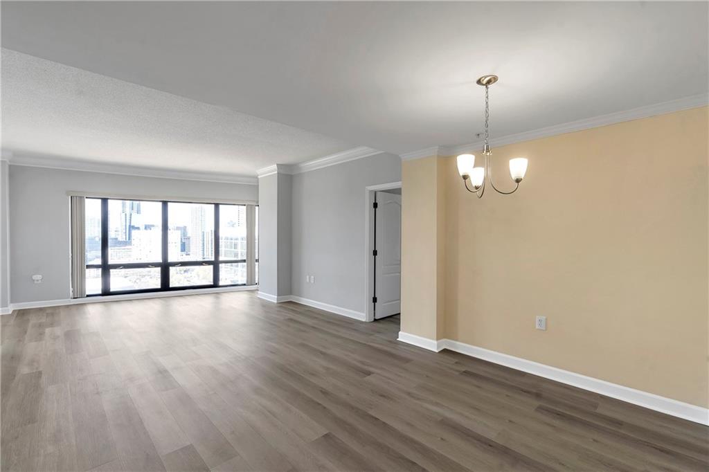 3475 Oak Valley Road Northeast, Unit 1930 Atlanta, GA 30326 - Photo 3 of 29 a view of an empty room with wooden floor and a window