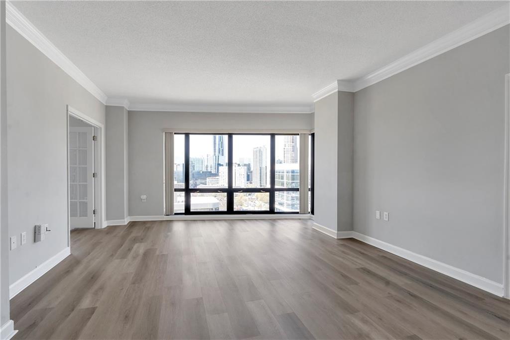 3475 Oak Valley Road Northeast, Unit 1930 Atlanta, GA 30326 - Photo 8 of 29 a view of an empty room with wooden floor and a window