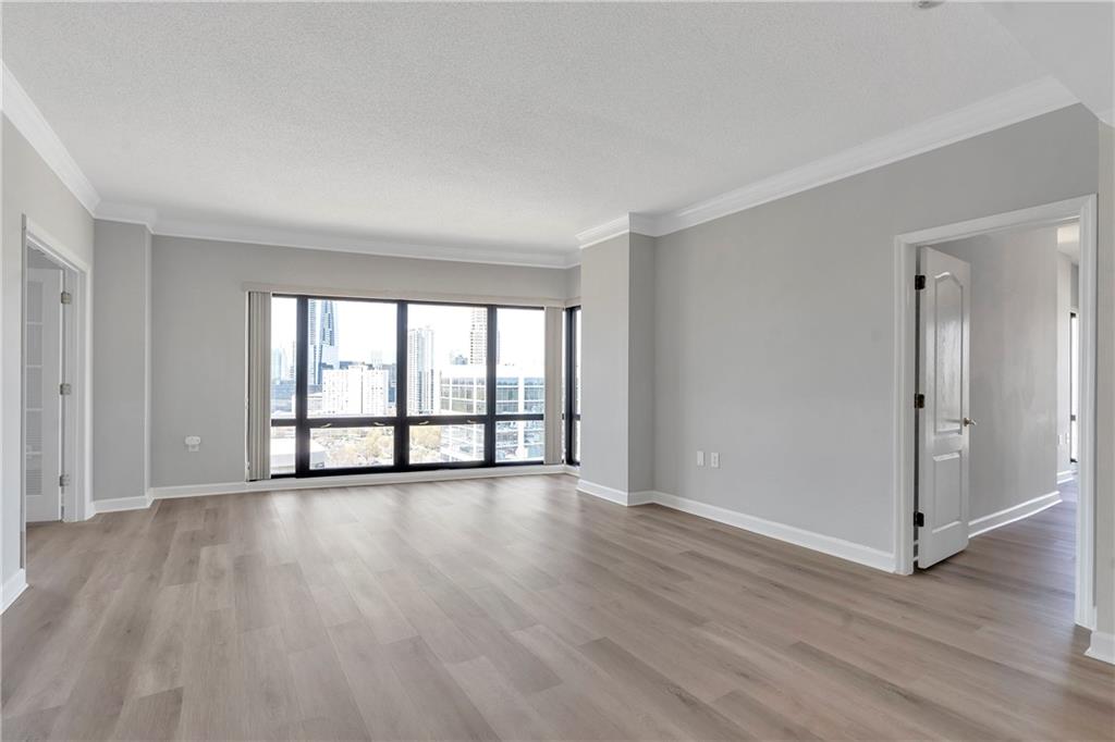3475 Oak Valley Road Northeast, Unit 1930 Atlanta, GA 30326 - Photo 9 of 29 a view of an empty room with wooden floor and a window