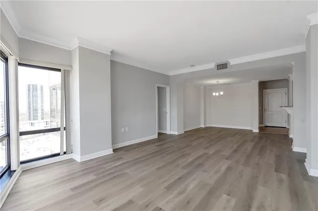 a view of an empty room with wooden floor and closet