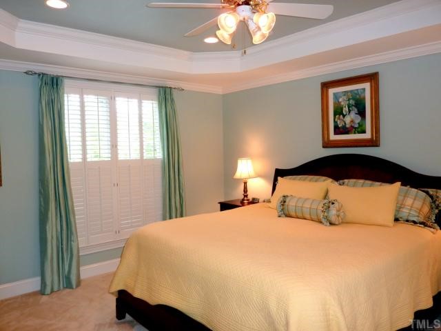 4617 White Chapel Way Raleigh, NC 27615 - Photo 7 of 12 a bedroom with a large bed and a chandelier
