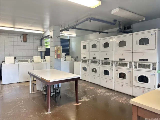 a kitchen with a refrigerator a white cabinets and wooden floor