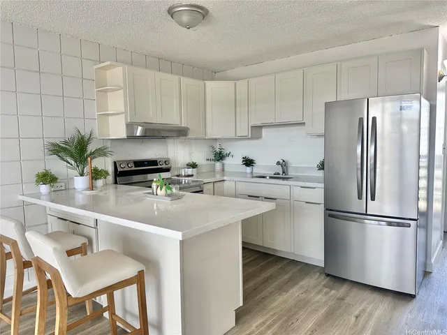 a kitchen with appliances a counter space and a refrigerator