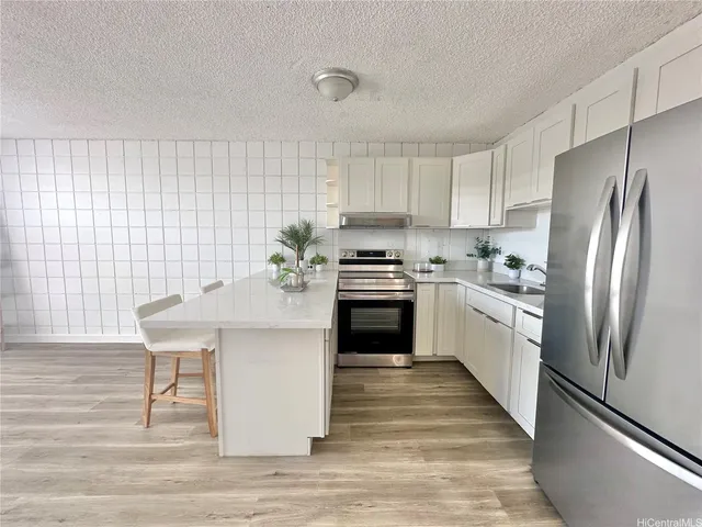 a kitchen with a sink stainless steel appliances and white cabinets