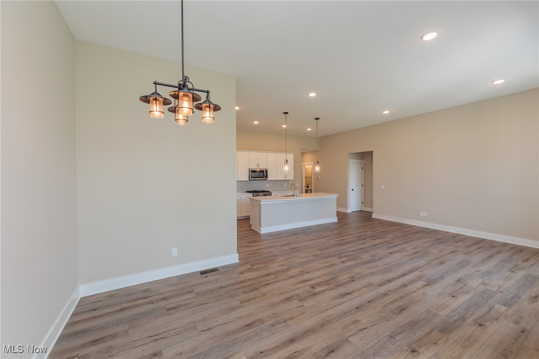 36458 Appian Way North Ridgeville, OH 44039 - Photo 6 of 37 Unfurnished living room with sink, a chandelier, and light hardwood / wood-style flooring