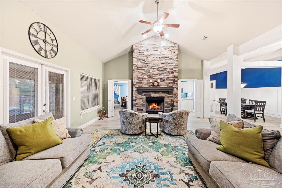 7191 Apples Way Navarre, FL 32566 - Photo 17 of 54 a living room with furniture a fireplace and a chandelier