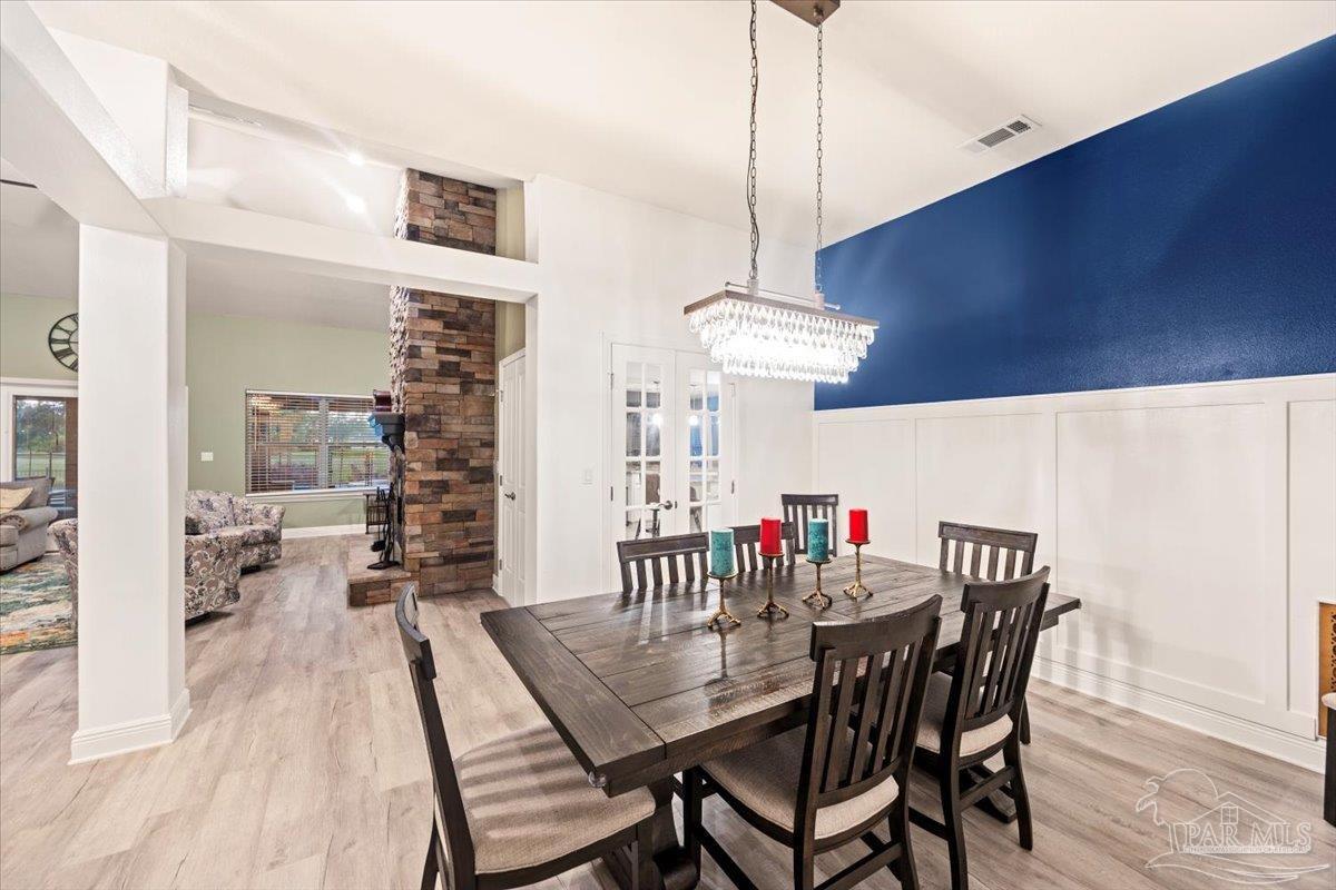 7191 Apples Way Navarre, FL 32566 - Photo 21 of 54 a view of a dining room with furniture and wooden floor