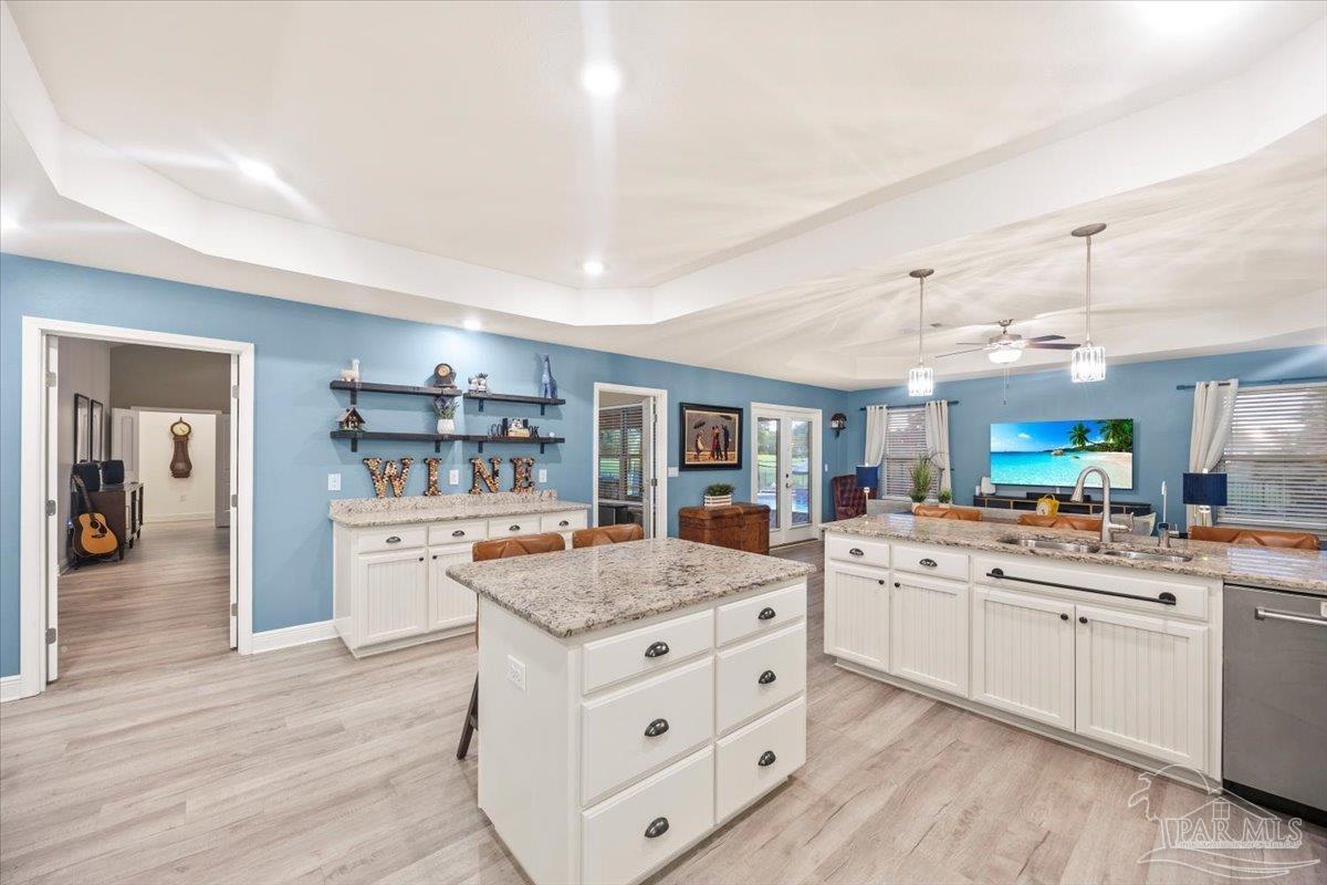 7191 Apples Way Navarre, FL 32566 - Photo 30 of 54 a kitchen that has a lot of cabinets in it and wooden floors