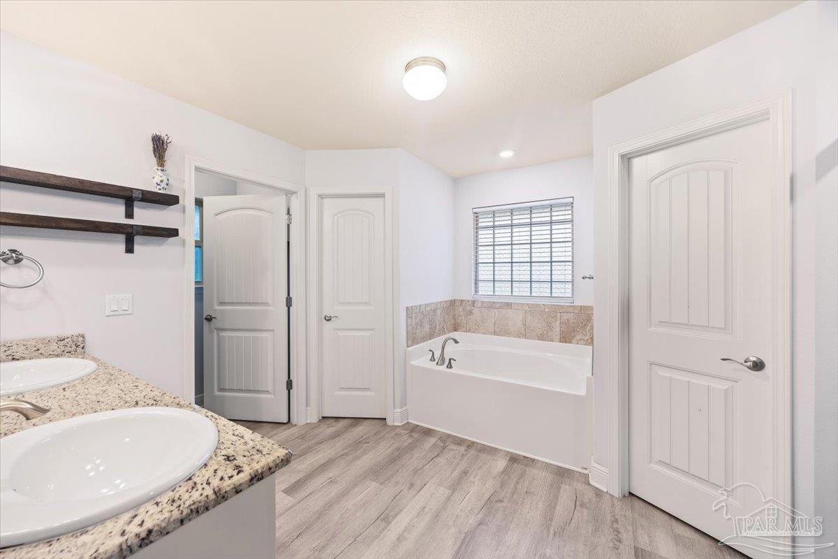 7191 Apples Way Navarre, FL 32566 - Photo 41 of 54 a spacious bathroom with a granite countertop tub sink and mirror
