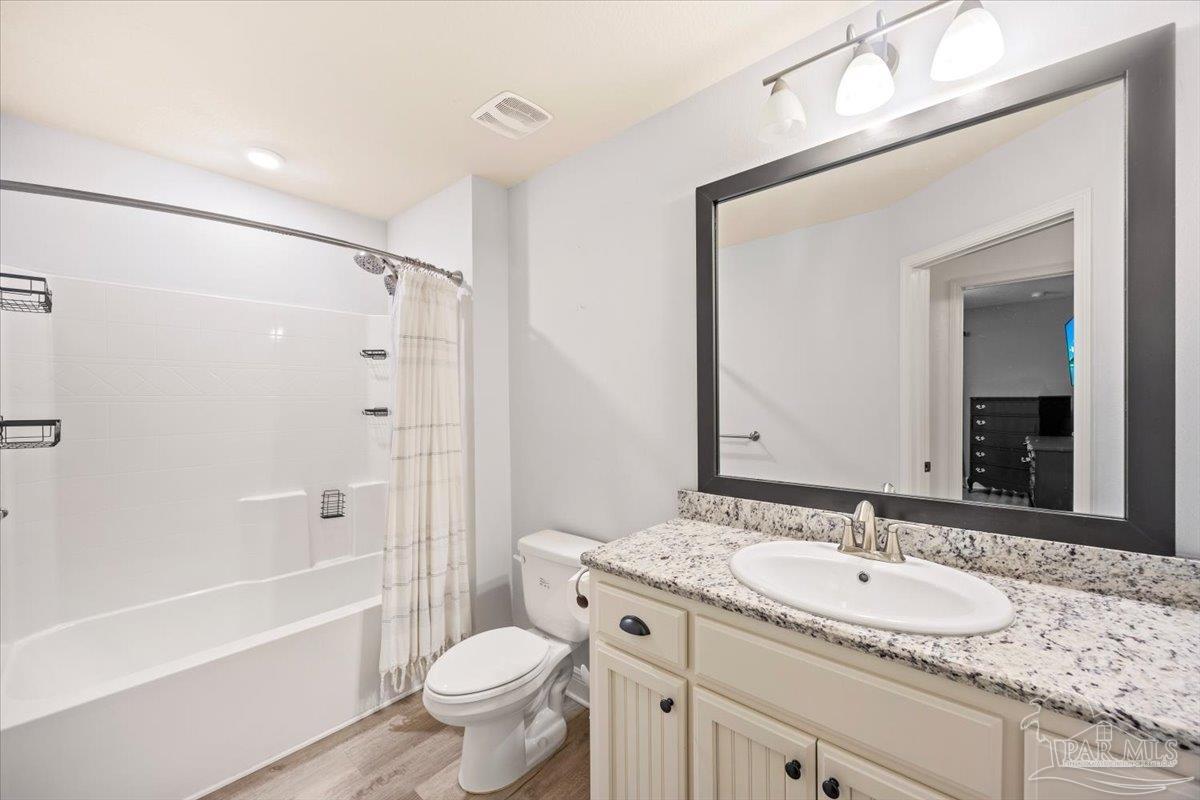 7191 Apples Way Navarre, FL 32566 - Photo 45 of 54 a bathroom with a granite countertop sink toilet mirror and shower