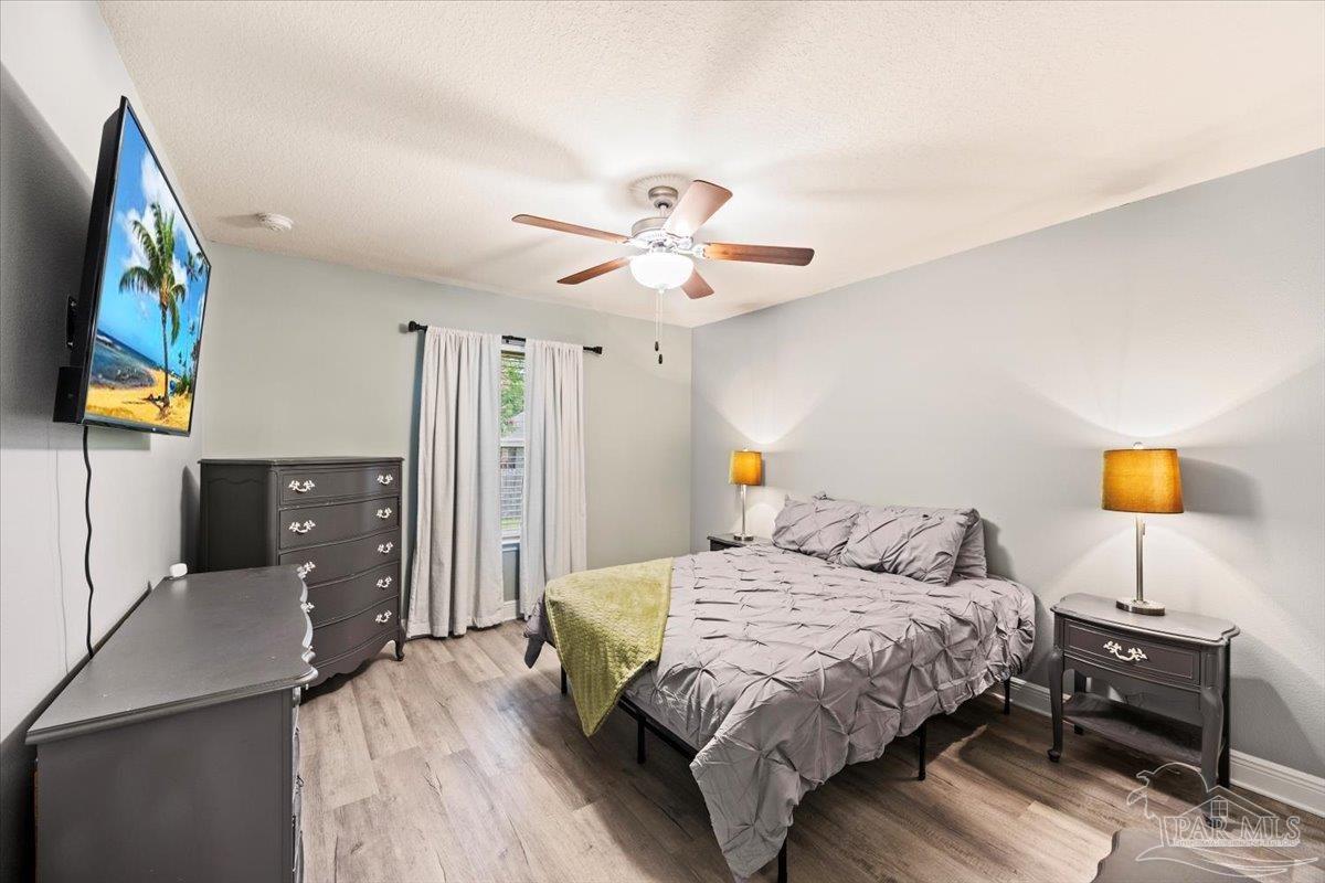 7191 Apples Way Navarre, FL 32566 - Photo 46 of 54 a bedroom with a bed and a chandelier