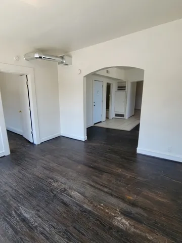 a view of a room with wooden floor and a ceiling fan